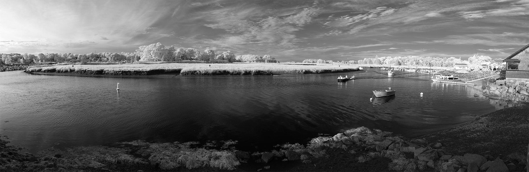 Infrared Panoramic Photo of a River Bend, with Boats in the Water and Marinas to Left and Right.